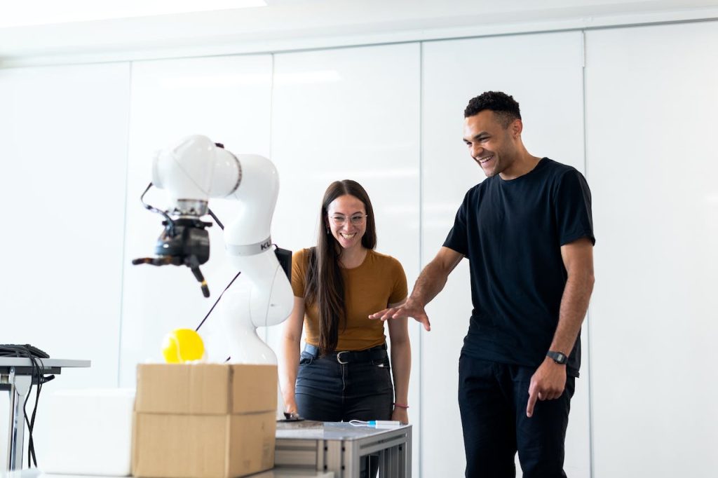 A couple playing with a robotic arm